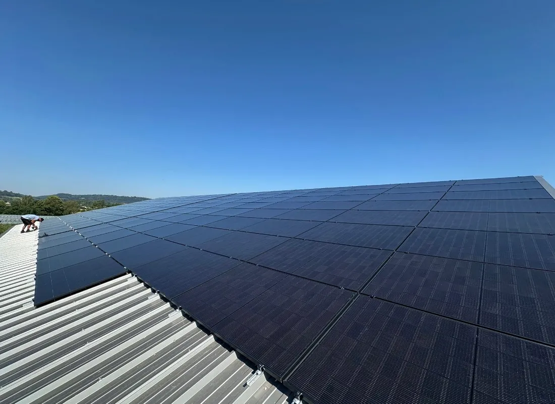 Großflächige PV-Anlage mit schwarzen Modulen auf einem Hallendach