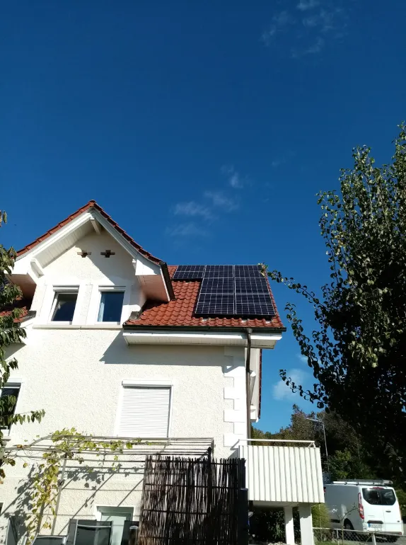 Photovoltaikanlage auf einem Einfamilienhaus vor blauem Himmel