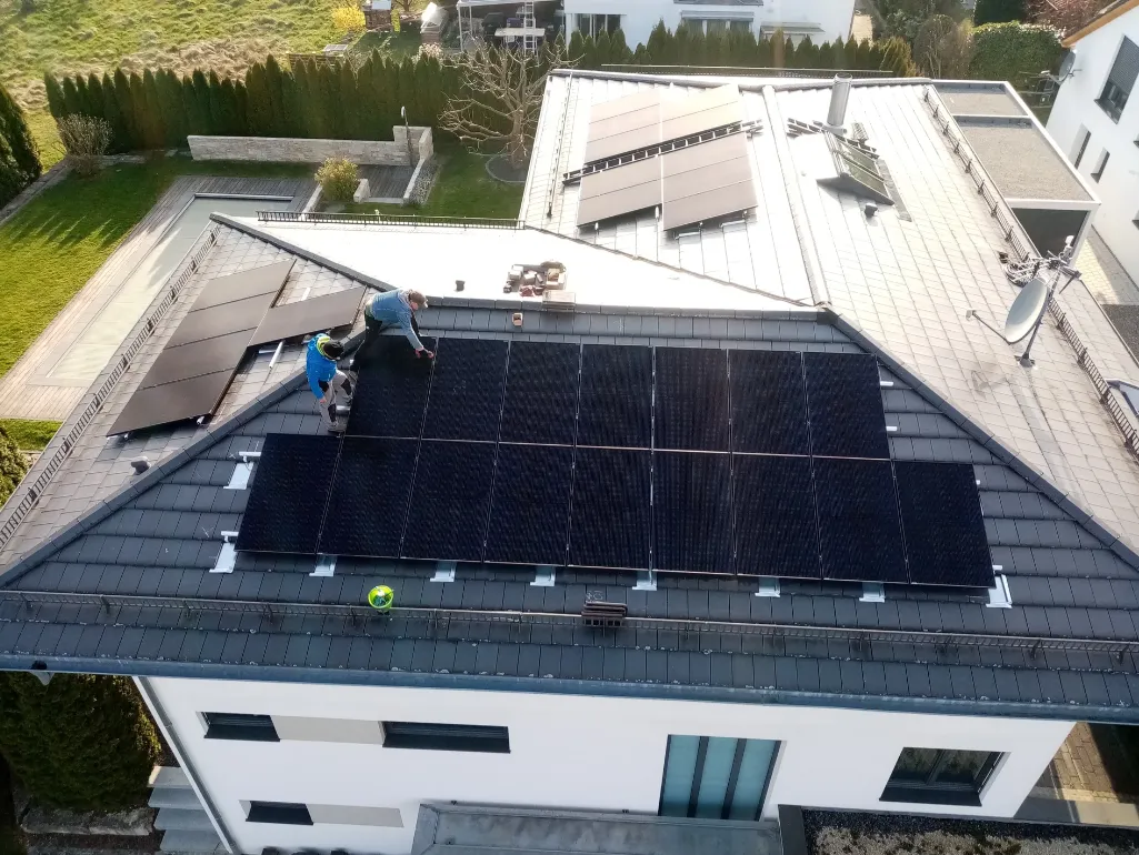 Montage schwarzer PV-Module auf einem modernen Wohnhaus